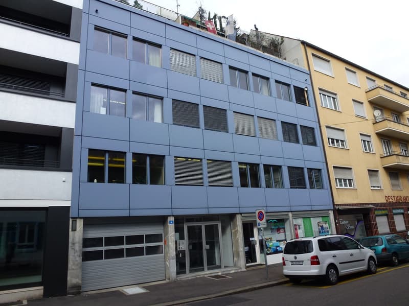 3 story building, gray garage, glass windows, store on the ground floor