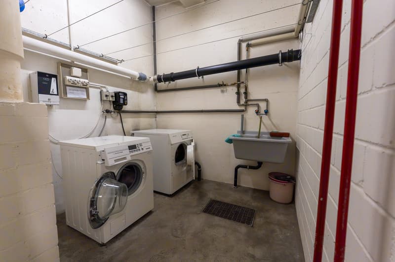 Laundry room with two washing machines and a sink
