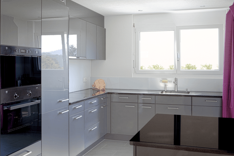 Modern kitchen with gray cabinets, stainless steel appliances, granite countertops, double oven and dishwasher