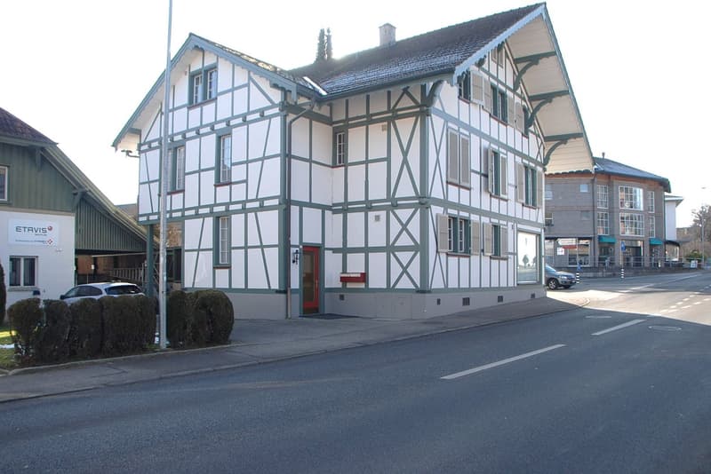 2 story house, white and green, raised ground floor, several windows, street view