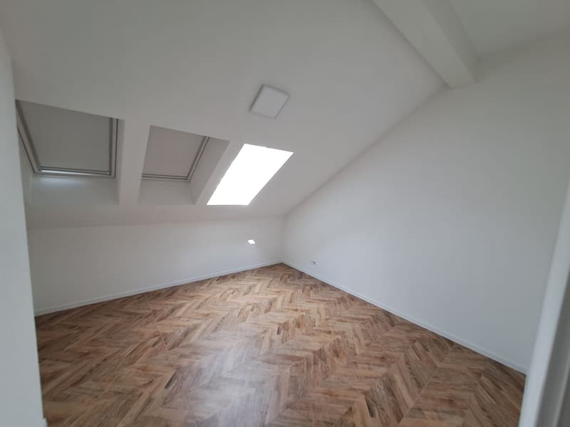 empty room, wooden parquet floor, white walls, three skylights