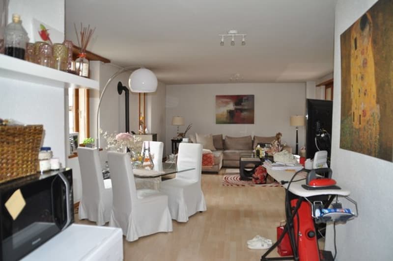 modern living room with white furniture, wooden floor, paintings, and lamps