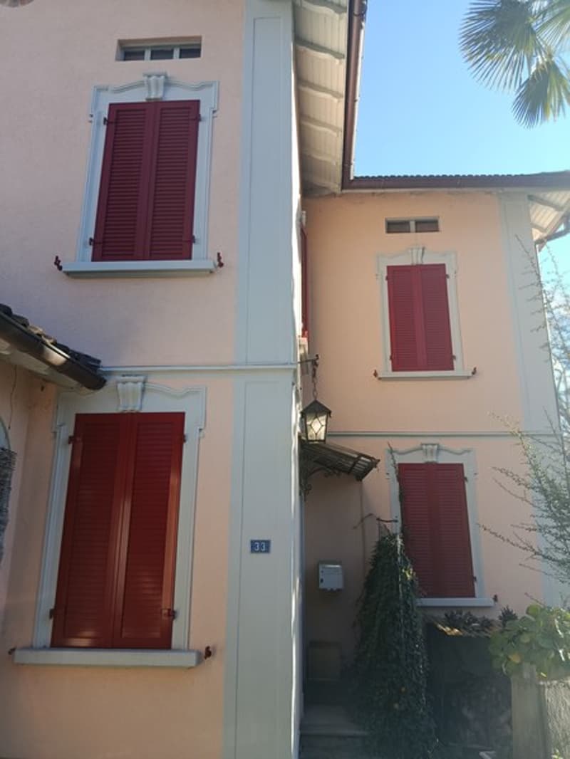 2 story house, red shutters, tan walls, chimney
