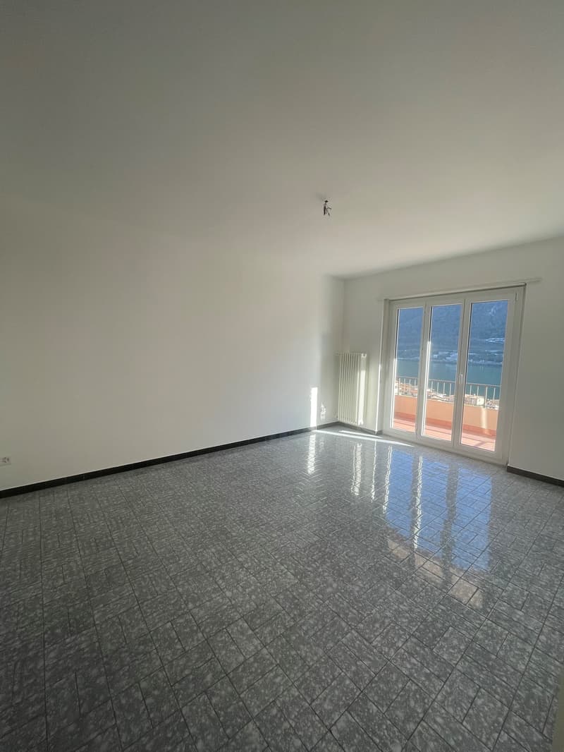 empty room, tile floor, sliding glass door, white walls, balcony with railings, power outlet