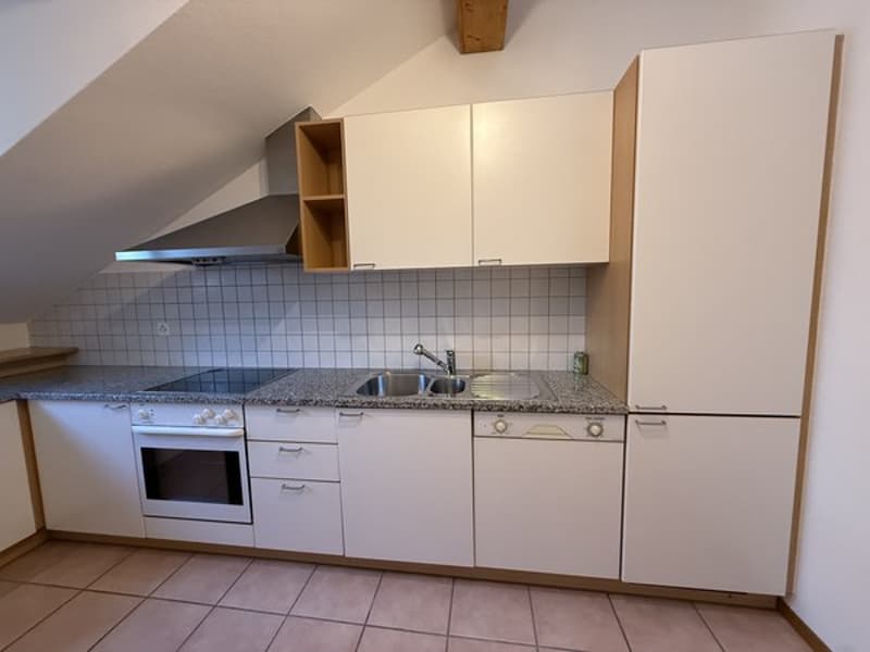 Modern, small kitchen with a gas stove, oven, sink with faucet, wooden ceiling, tiled floor, white cupboards, white appliances, and granite countertops.