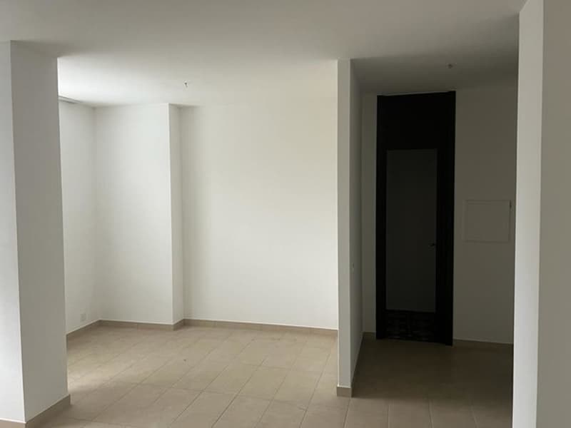 Empty room, white walls, tiled floor, white ceiling, pillar, door