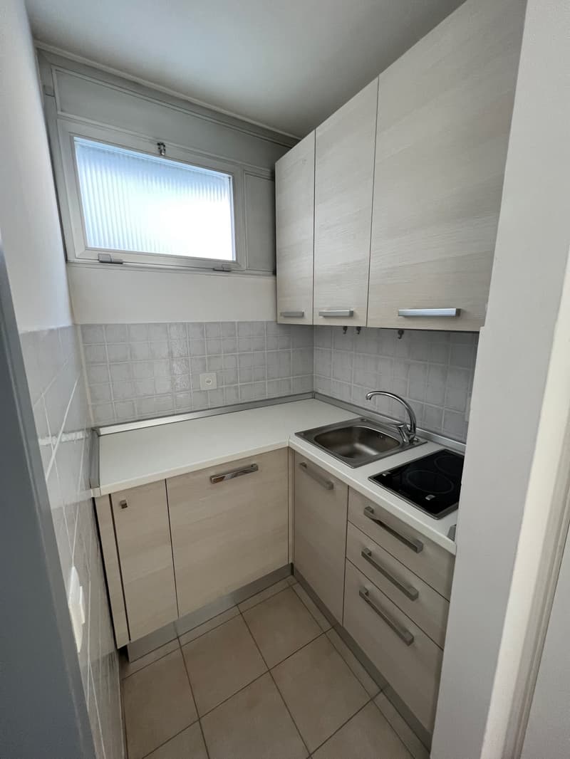 kitchen with wooden cupboards, stainless steel sink, electric hob, power outlet, white tiled floor