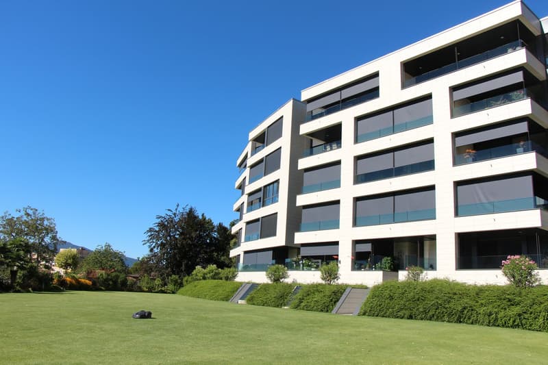 modern apartment building, glass balconies, spacious lawn