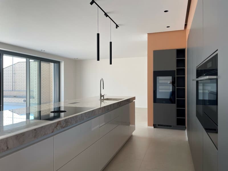 modern kitchen with granite countertop, stainless steel faucet, built-in microwave, refrigerator, and oven