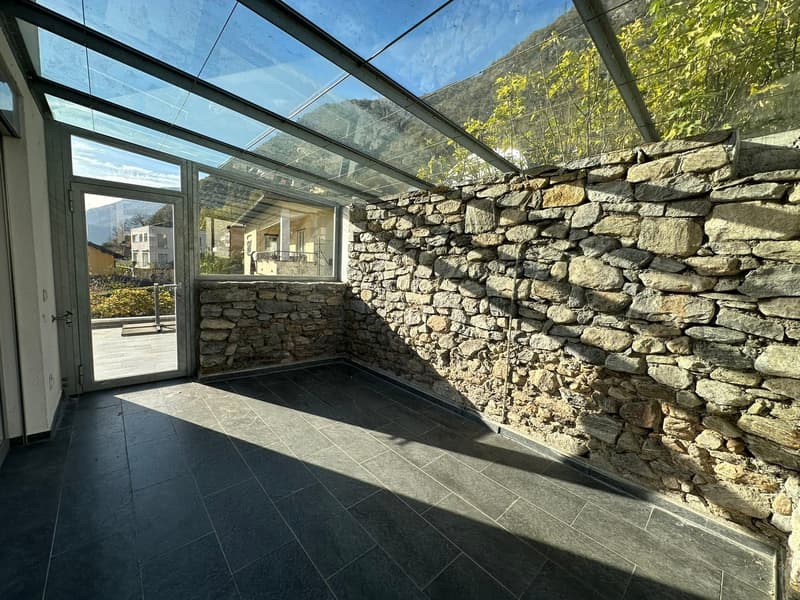 stone wall, tiled floor, glass walls, glass door, mountains visible