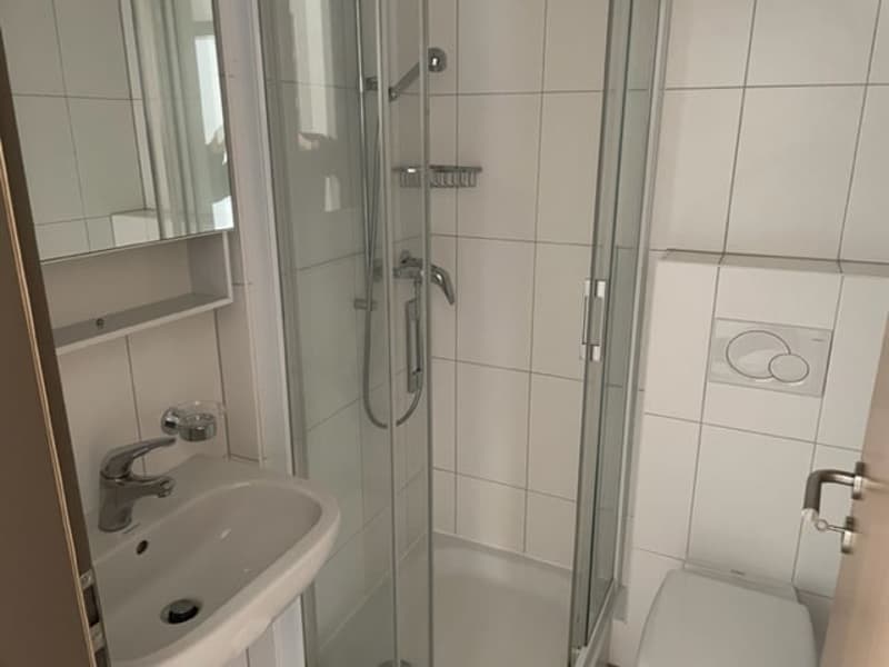 Tiled bathroom with a shower enclosure, sink, and toilet