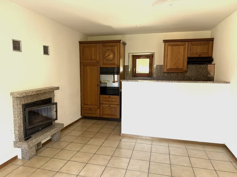 Spacious kitchen with wooden cabinets, granite countertops, built-in oven, and a fireplace in the corner.