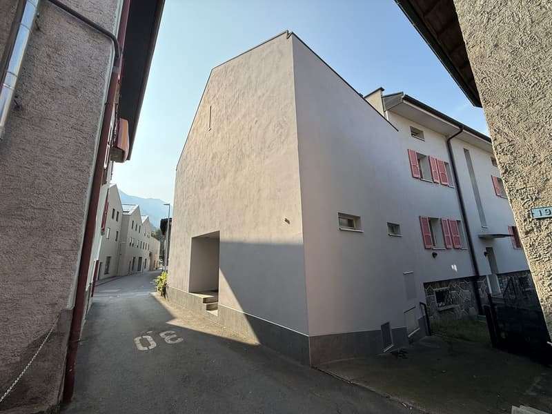 Corner residential building with a car entrance in the back