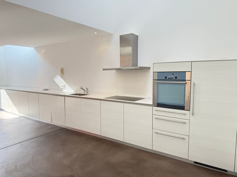 modern kitchen, white cabinets, stainless steel appliances, dark countertop, exhaust hood, sink, oven, open space