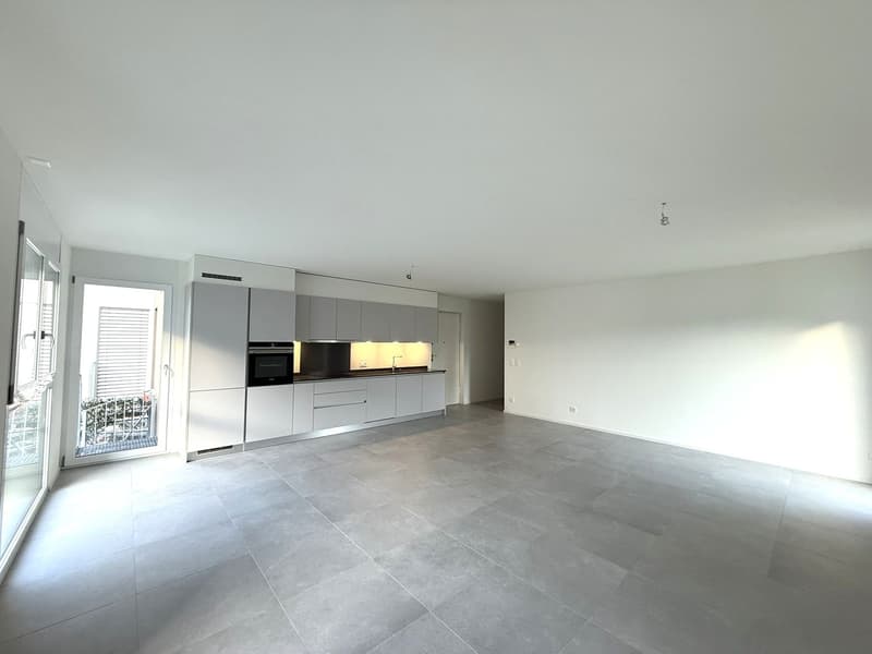 Empty kitchen with modern design, open balcony, large windows, grey tiled floor