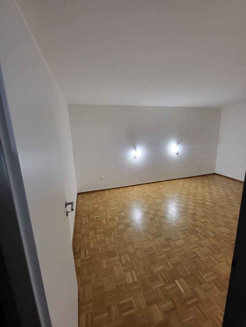 empty room, wooden floor, white walls, two wall lights