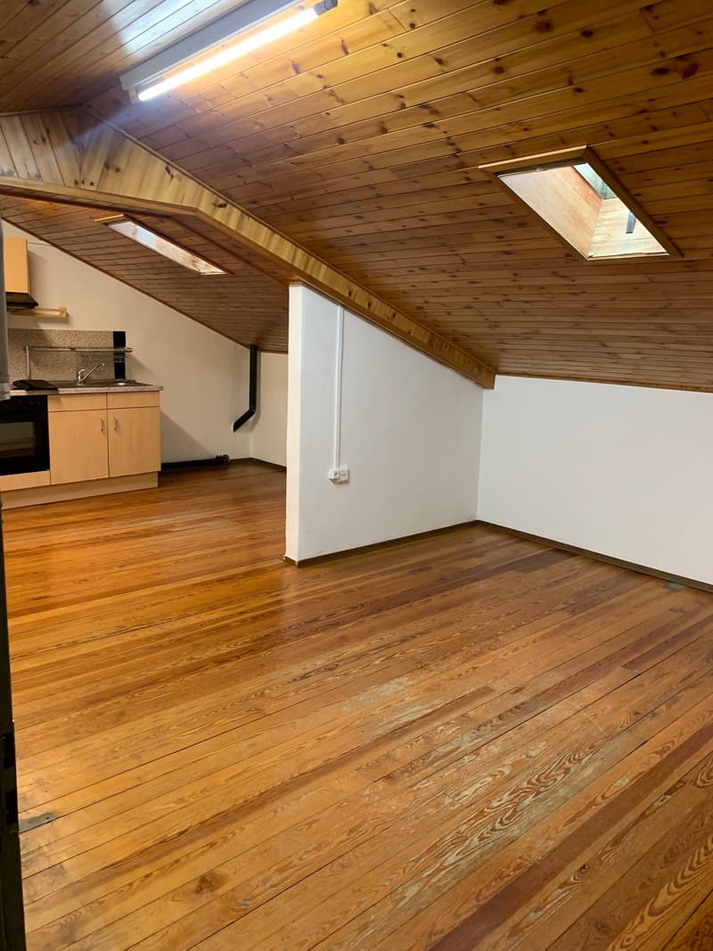 wooden floors, vaulted ceiling, skylights, kitchen area with cabinet and sink, black oven