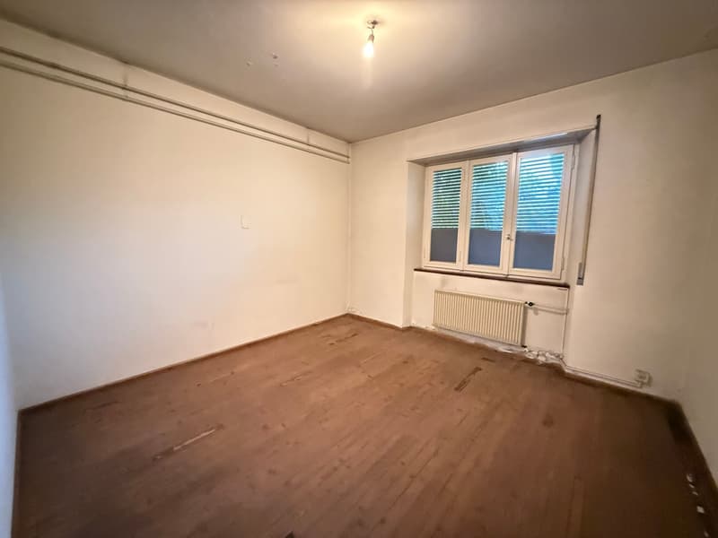 empty room, wooden floor, white walls, windows with blinds, radiator