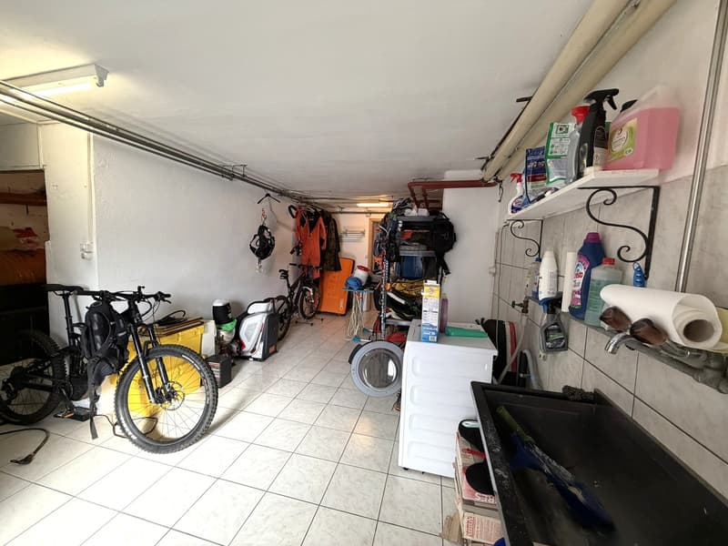 Storage room with bicycles, washing machine, cleaning products, and various items