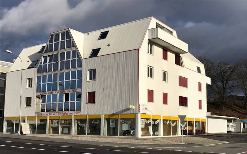 modern building with glass windows, yellow and white trim, two stories, balcony