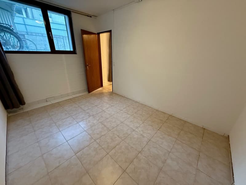 Empty room, tiled floor, open door, window with view to outside
