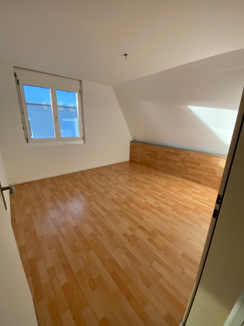 empty room with wooden floor, a window, an outlet