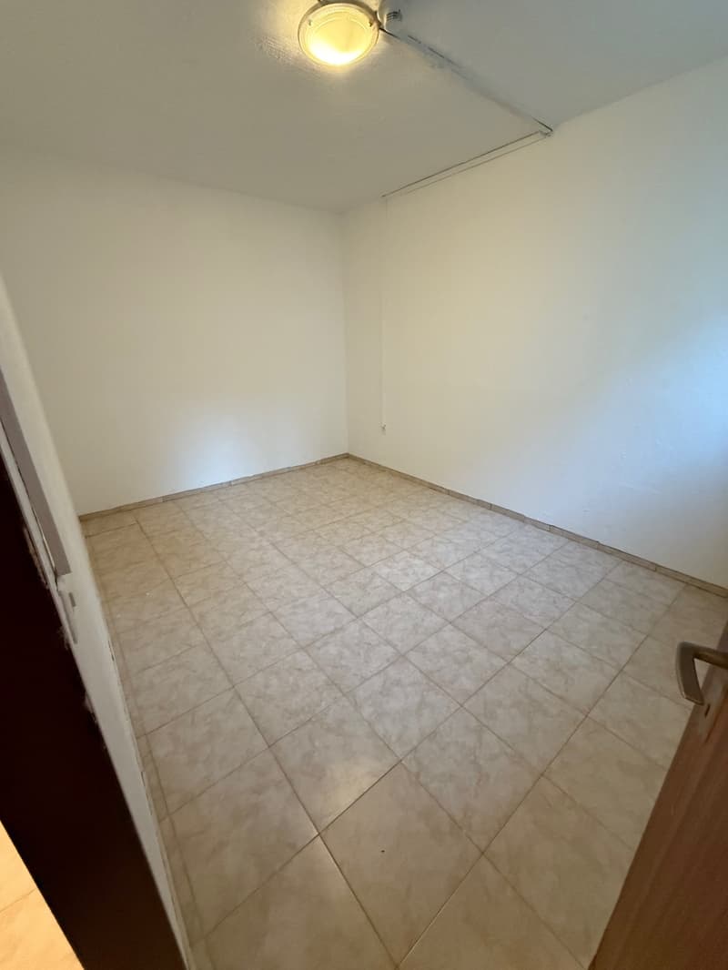 tiled floor, white walls, a ceiling lamp, open door