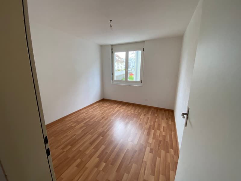 Empty room with wooden flooring, white walls, and a window with blinds. No furniture or equipment present.
