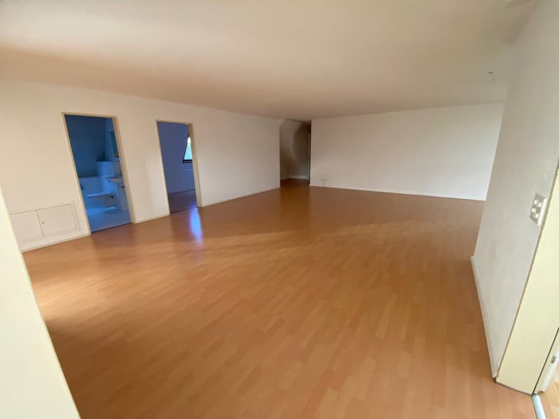empty room with wooden floor, white walls, three doors, power outlet