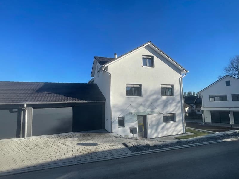 2 story house, white exterior, 2 garages, paved driveway