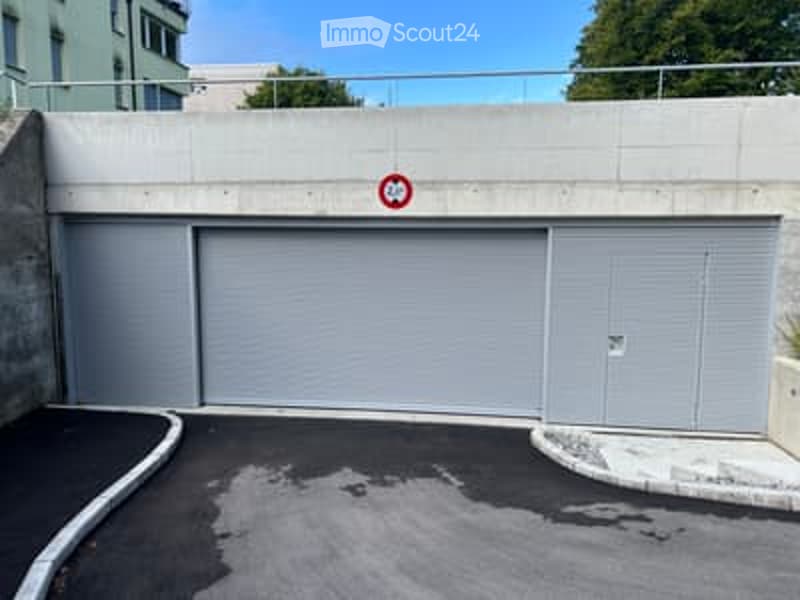 underground parking area, concrete structure, grey garage doors