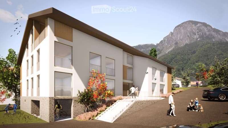 white building with glass windows, balcony, garage entrance, concrete pathway, mountain background