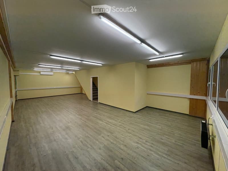 Wooden floors, yellow walls, fluorescent ceiling lights, two doors with white trim, glass window, staircase