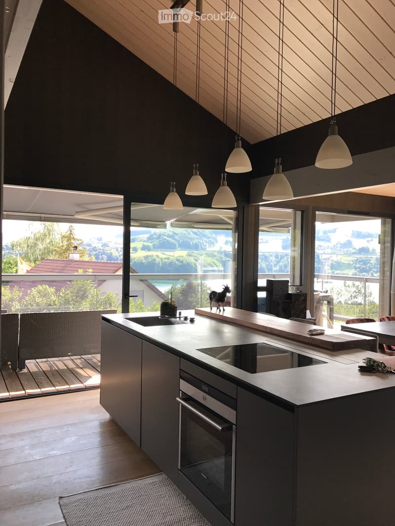Modern kitchen, large windows, balcony, central island, contemporary lighting, rustic wooden counter