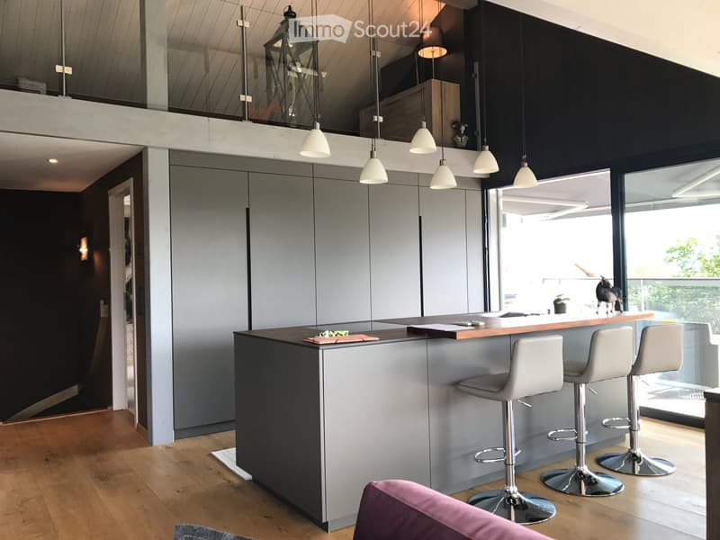 Modern kitchen, open plan, grey cabinets, island, breakfast bar, 3 bar stools, hanging lamps, glass balcony