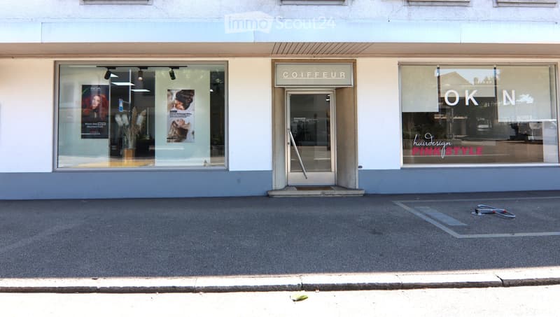Modern, white exterior, large glass windows, entry door, signage, sidewalk