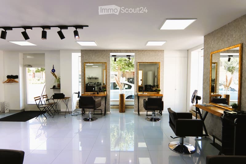 Large room, white floor, large windows, chairs and desks, mirrors, large table, ceiling lights, plants