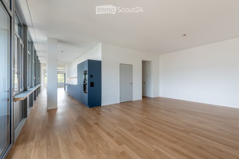 Unfurnished Room. Empty room with light wooden flooring, white walls, and large windows. No furniture or equipment is present.