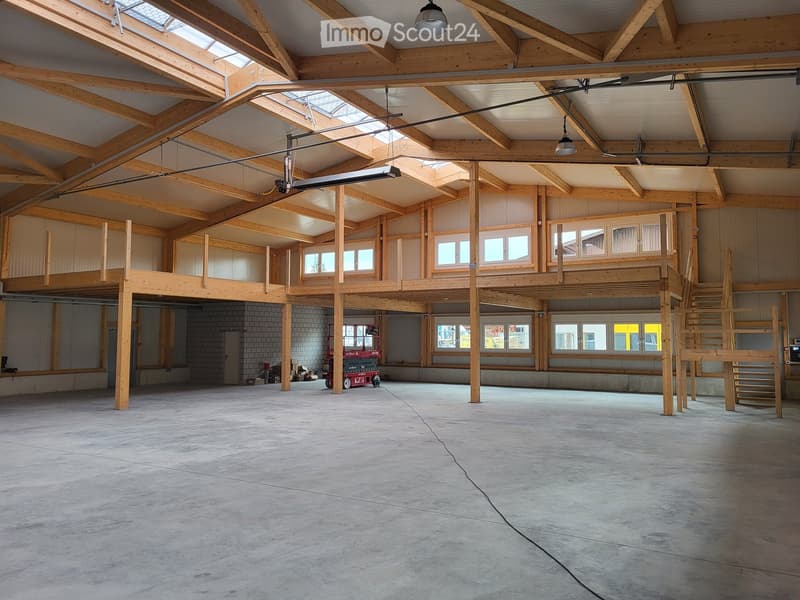 Large garage, wooden trusses, windows, red forklift, wooden stairs