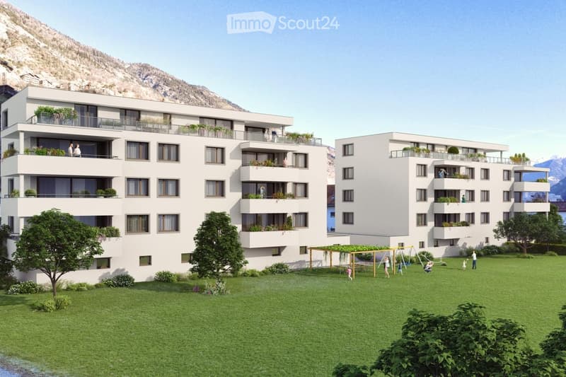 Two white apartment buildings with balconies, green lawn, playground, and mountain view