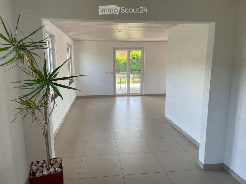 Empty room with tile flooring, white walls, and an entrance to a balcony with an outdoor view
