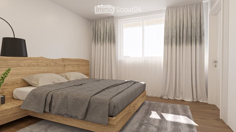 A bedroom with a wooden bed, two pillows, a gray blanket, a wooden headboard, a gray rug, a black lamp, a plant, and a window with white curtains.