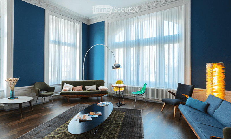 blue walls, wooden floor, 2 sofas, coffee table, lamps, large windows
