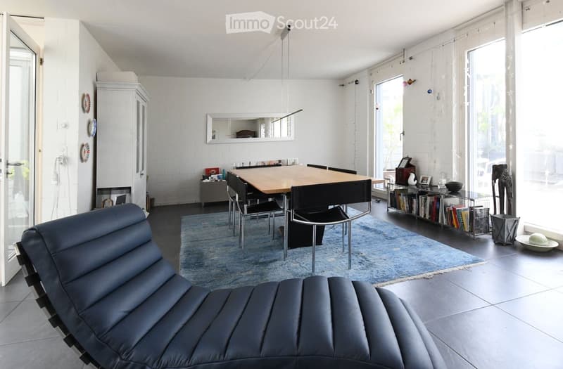 Modern design, large dining table, blue carpet, black lounge chair, floor to ceiling windows