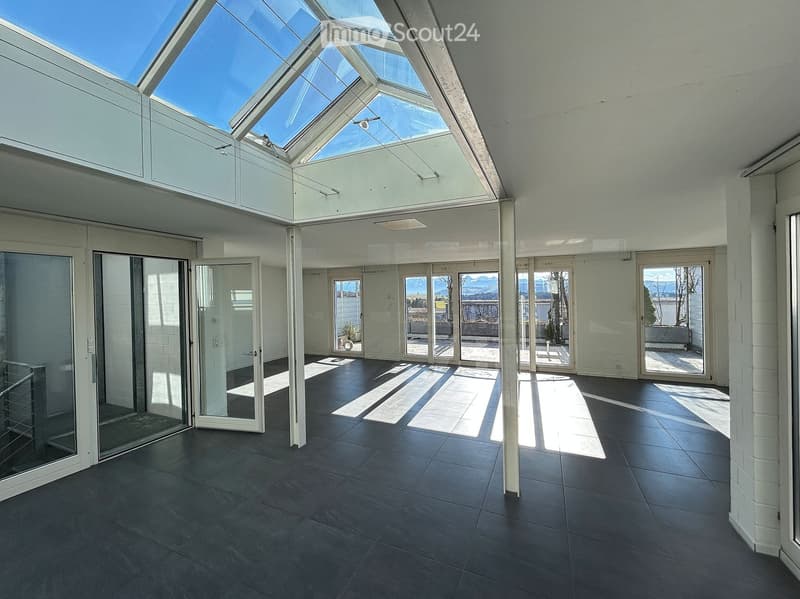 Open room with skylight, glass doors, tiled floor, panoramic view of the mountains