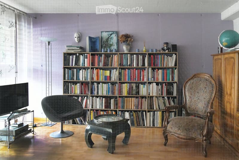 living room with wooden floor, bookshelves, chair, table, television, cabinet