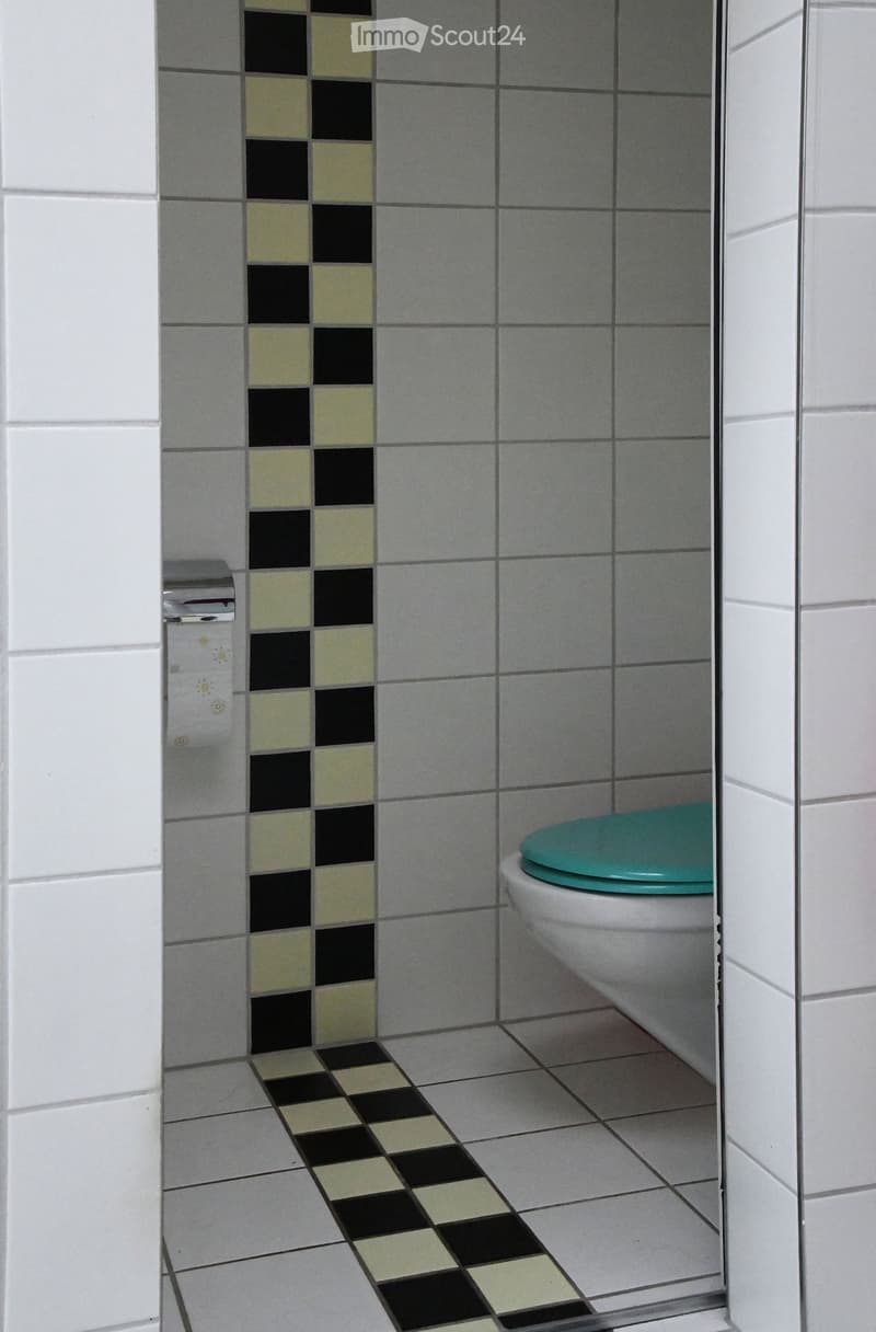 small bathroom with checkered tiles, white toilet, white walls