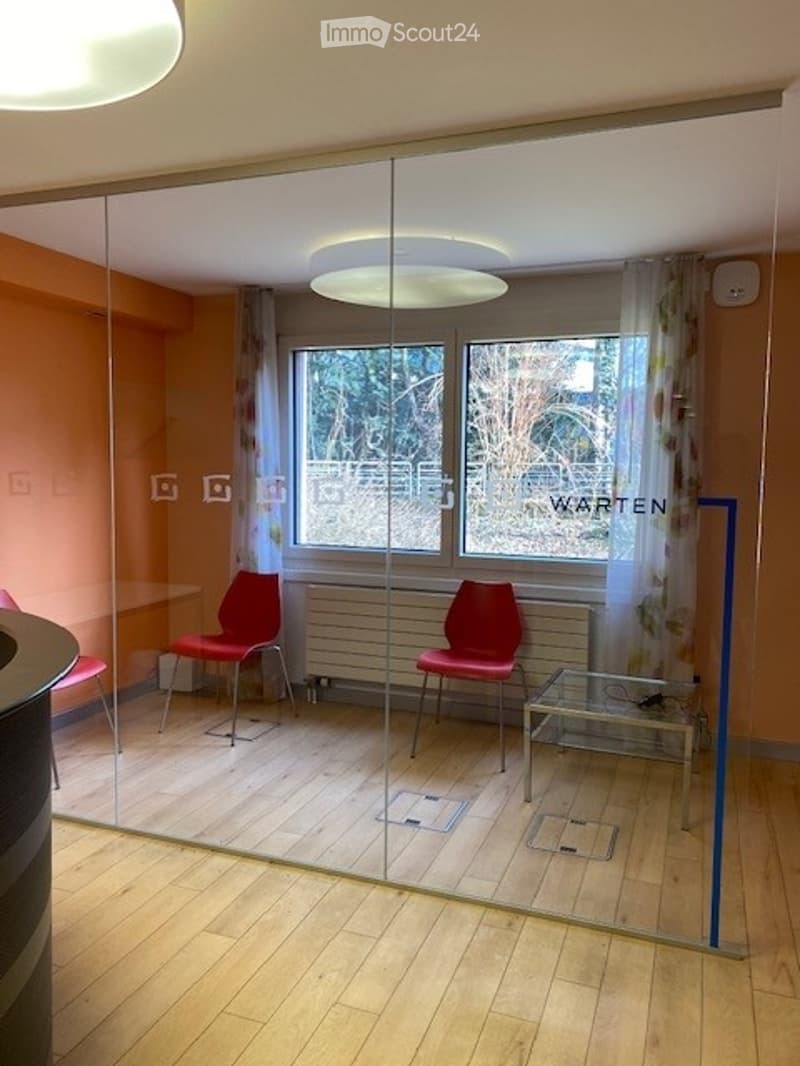 An empty meeting room with glass walls and a radiator