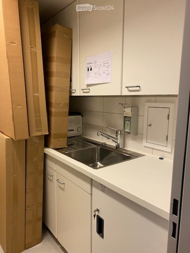 kitchen with sink, cabinets, countertop and stacked boxes