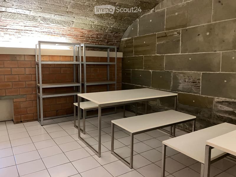 Storage room, brick walls, tiled floor, metal shelving units, benches, desk